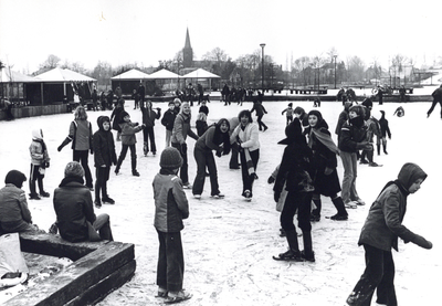 94165 Afbeelding van een groot aantal schaatsende kinderen op het ondergelopen en bevroren schoolplein van de Maarten ...